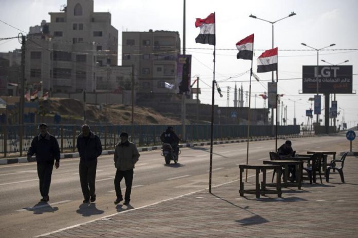 warga-palestina-berjalan-melewati-bendera-mesir-di-sisi-jalan_220214193413-226